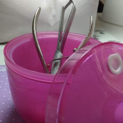 Recipiente rosa translúcido com pinças metálicas e tampa cor-de-rosa