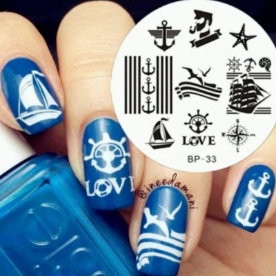 Unhas azuis com desenhos brancos de temas marítimos e chapa de carimbos com símbolos náuticos