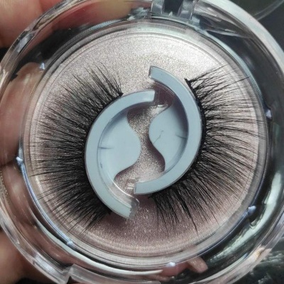 Pestanas falsas pretas na embalagem circular transparente com interior rosa