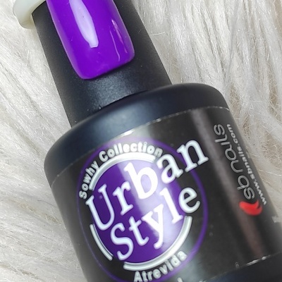 Frasco de verniz de unhas Urban Style e amostra roxa sobre fundo branco felpudo