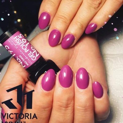 Mãos com unhas cor de rosa púrpura em formato oval segurando frasco de verniz gel