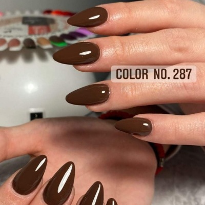 Unhas compridas pintadas de castanho brilhante com formato amendoado