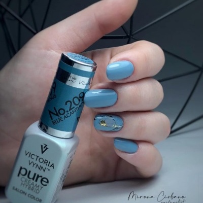 Esmalte de unhas Victoria Vynn azul claro com unha decorada e fundo geométrico escuro