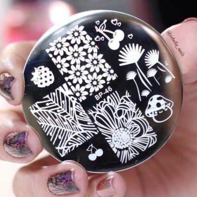 Placa metálica redonda para carimbos de unhas com desenhos brancos sobre fundo preto