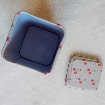 Caixa metálica quadrada decorada com cerejas vermelhas