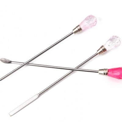 Três utensílios metálicos com cabos em forma de gema rosa