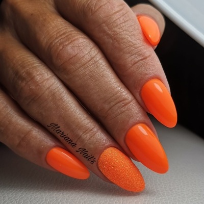 Mão com unhas em gel laranja fluorescente, uma com textura granulado e texto 'Mariana Nails'