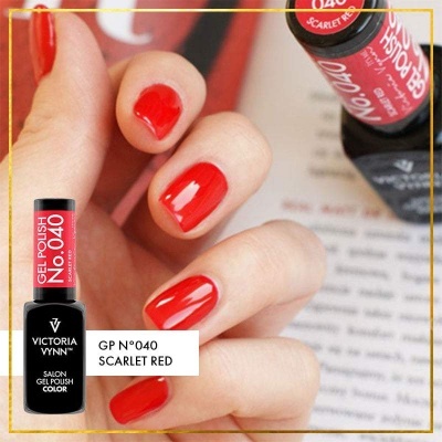 Unhas pintadas de vermelho com esmalte Victoria Vynn GP 040 Scarlet Red junto ao frasco do produto