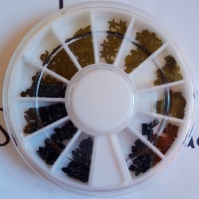 Caixa redonda com pequenos ornamentos de decoração de várias formas e cores