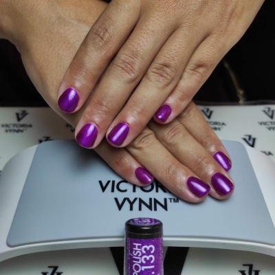 Mãos com unhas roxas metálicas sobre lâmpada VICTORIA VYNN e verniz GEL POLISH No.133
