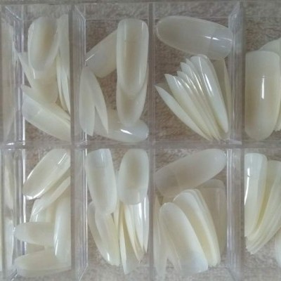 Unhas postiças brancas organizadas em caixas plásticas