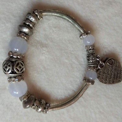 Pulseira prateada com contas e pendente de coração com texto