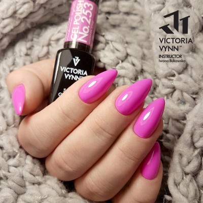 Mão com unhas pintadas de rosa vibrante segurando verniz VICTORIA VYNN número 253