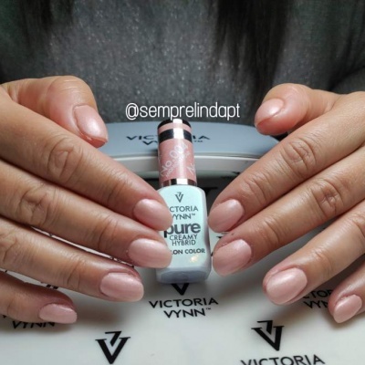 Mãos femininas segurando frasco de verniz Victoria Vynn Pure