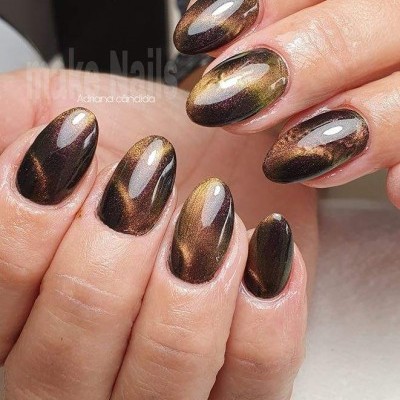 Unhas com verniz castanho e dourado metalizado, formato oval, mãos femininas