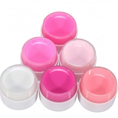 Seis frascos pequenos de creme em tons de rosa e branco com tampa branca.