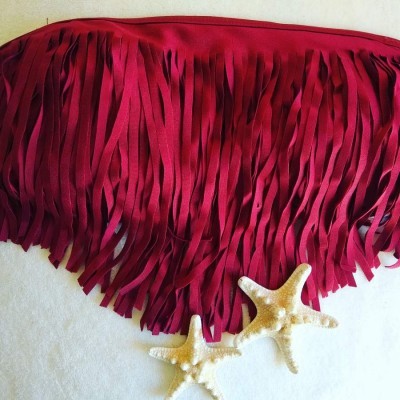 Parte de cima de biquíni vermelho com franjas e duas estrelas do mar