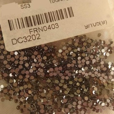 Pacote transparente com pedras metálicas e etiqueta com código de barras