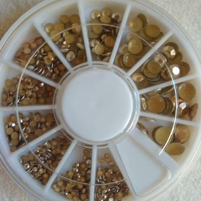 Caixa redonda com pedras decorativas douradas de vários tamanhos