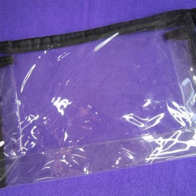 Bolsa transparente de plástico com bordas pretas sobre fundo roxo