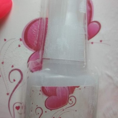 Frasco de cola para unhas com rótulo de corações e texto