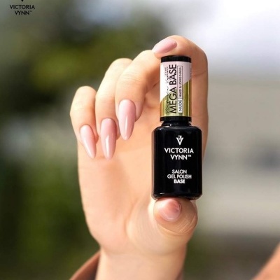 Unhas rosas claras seguram frasco preto de verniz gel VICTORIA VYNN