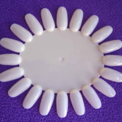 Mostruário circular de unhas postiças brancas em fundo roxo