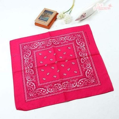 Pano vermelho com padrão branco estilo bandana, caixa de fósforos e vaso com flor branca