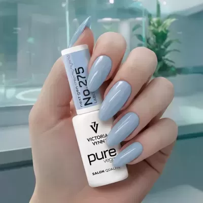 Mão com unhas azul claro segurando frasco de verniz Victoria Vynn pure vegan