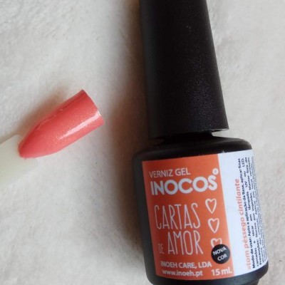 Frasco de verniz gel INOCOS cor coral com amostra em unha branca