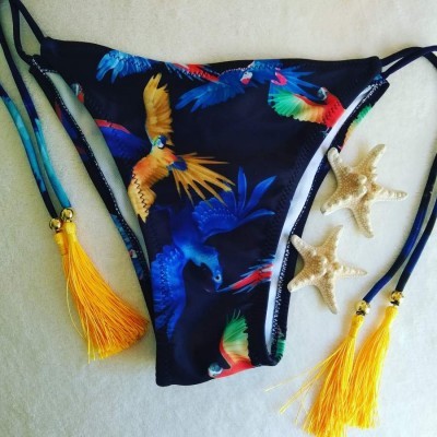 Cuecas de biquíni com padrão de papagaios e tasséis amarelos