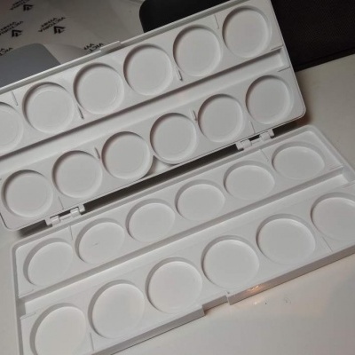Paleta branca plástica para mistura de tintas aberta com doze círculos vazados