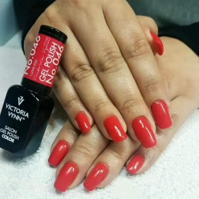 Unhas vermelhas com verniz gel e garrafa de verniz Victoria Vynn