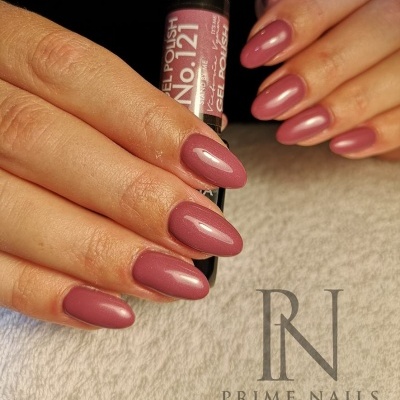 Unhas com esmalte gel rosa velho segurando frasco de esmalte preto
