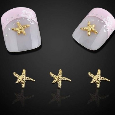 Unhas postiças rosa claro decoradas com flores, cristais e estrelas-do-mar douradas