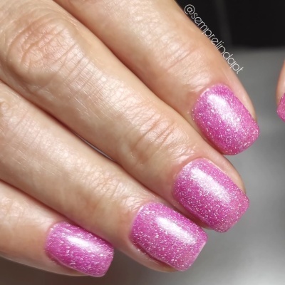 Unhas pintadas de rosa cintilante com glitter