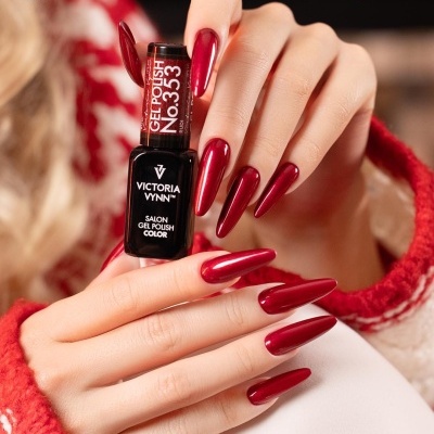 Mãos femininas com unhas vermelhas seguram verniz de gel Victoria Vynn