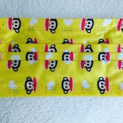 Máscara amarela com padrão de macacos com boné e óculos