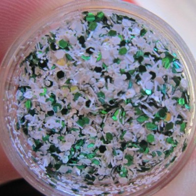 Frasco transparente com purpurinas verdes e brancas em forma de triângulos e flores