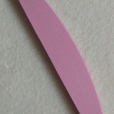 Lima de unhas cor-de-rosa sobre fundo branco texturizado