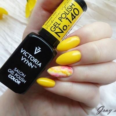 Esmalte de gel amarelo Victoria Vynn No. 140 em unhas alongadas com uma unha decorada em tons de rosa e amarelo