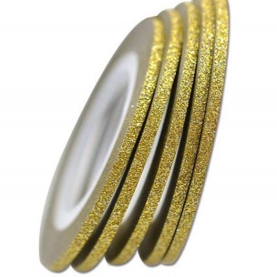 Anéis dourados finos com glitter empilhados sobre fundo branco