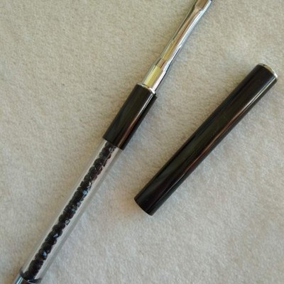 Pincel de maquilhagem com cabo transparente e pedras pretas