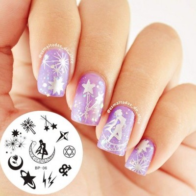 Unhas pintadas com verniz lilás e desenhos brancos de estrelas e figuras femininas.