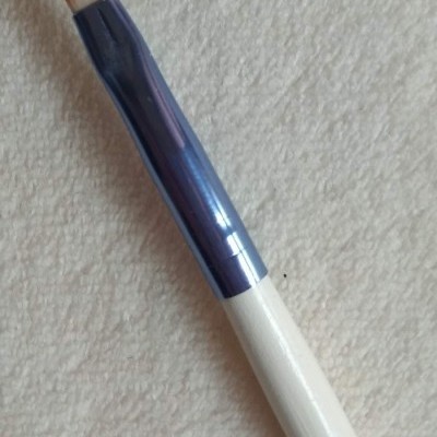 Pincel de maquilhagem com cabo branco e suporte metálico azul e cerdas castanhas