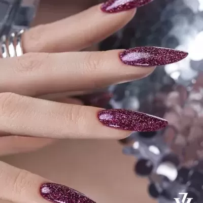 Unhas compridas com verniz vinho brilhante e glitter, com texto 'VICTORIA VYNN CANADA' no canto inferior direito.