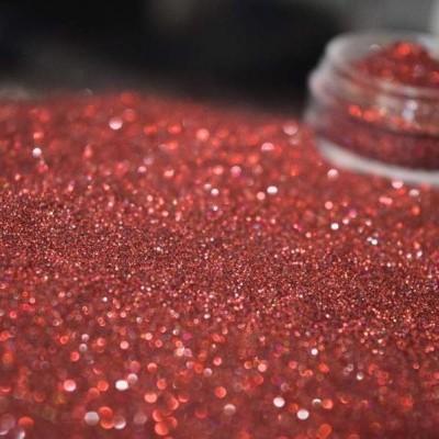 Glitter vermelho brilhante espalhado com frasco pequeno aberto ao fundo
