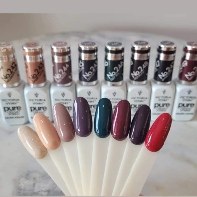Amostras de verniz de unhas em vários tons com garrafas Victoria Vynn Pure ao fundo