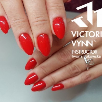 Unhas vermelhas brilhantes formato amendoado com texto VICTORIA VYNN INSTRUCTOR