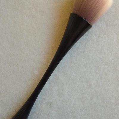 Pincel de maquiagem com cabo preto e cerdas macias em tons claros